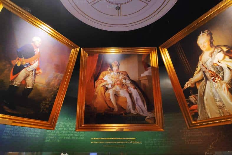 Three painting hanging on display at the POLN Museum in Warsaw