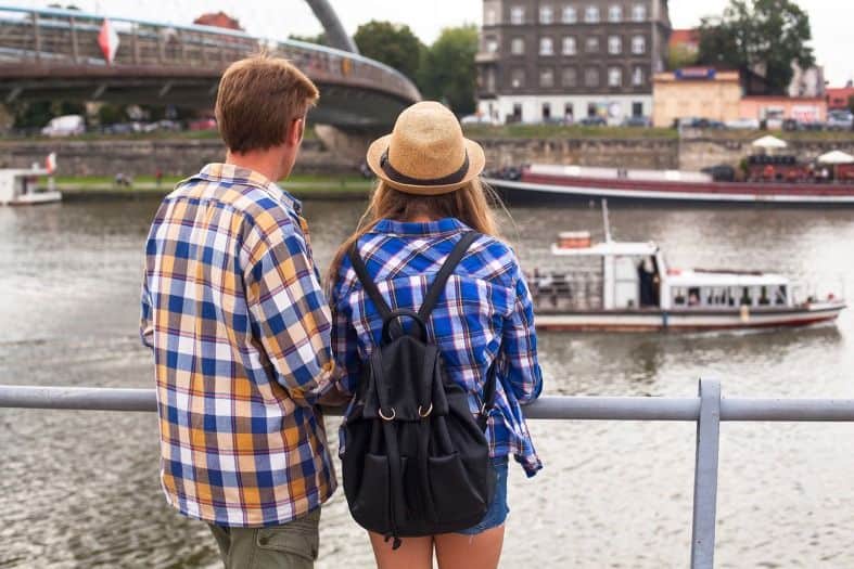 a couple standing on the banks of the Vistula River in Krakow