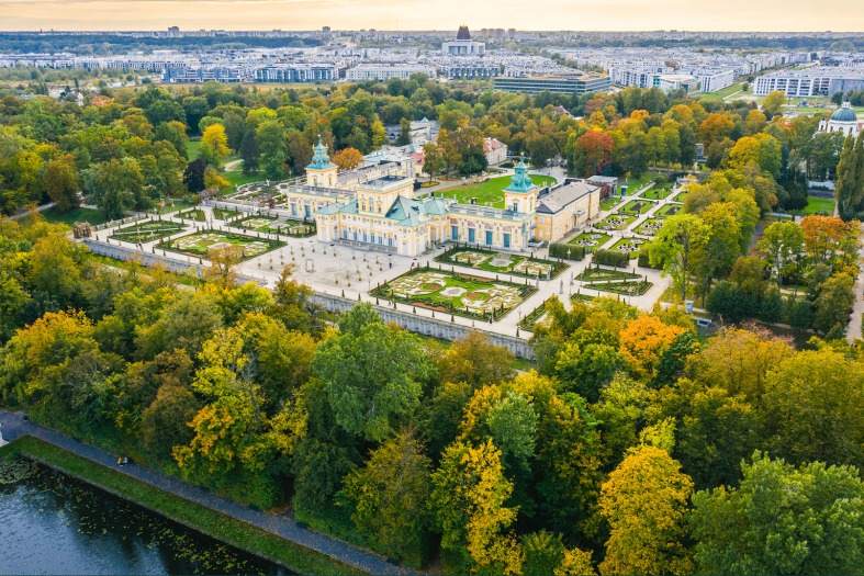 Ariel view of Wilanow Palace surrounded by trees with Warsaw in the background