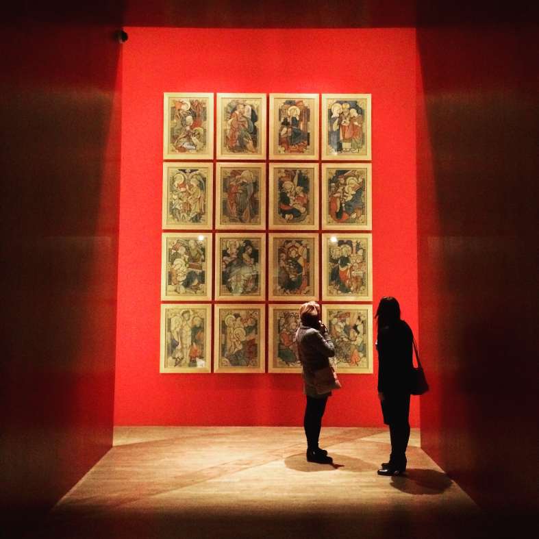 Two people in a red room looking at painting in the National Musem in Krakow